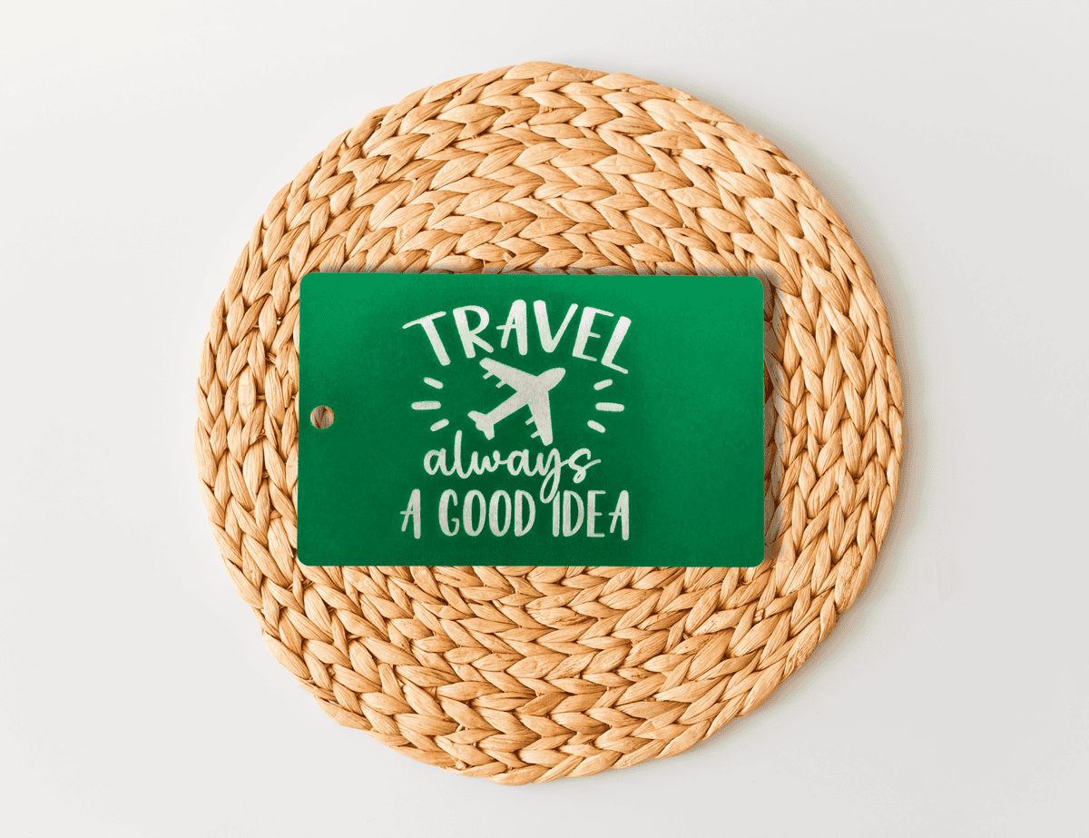Green engraved luggage tag with airplane graphic and the phrase “travel always a good idea.”