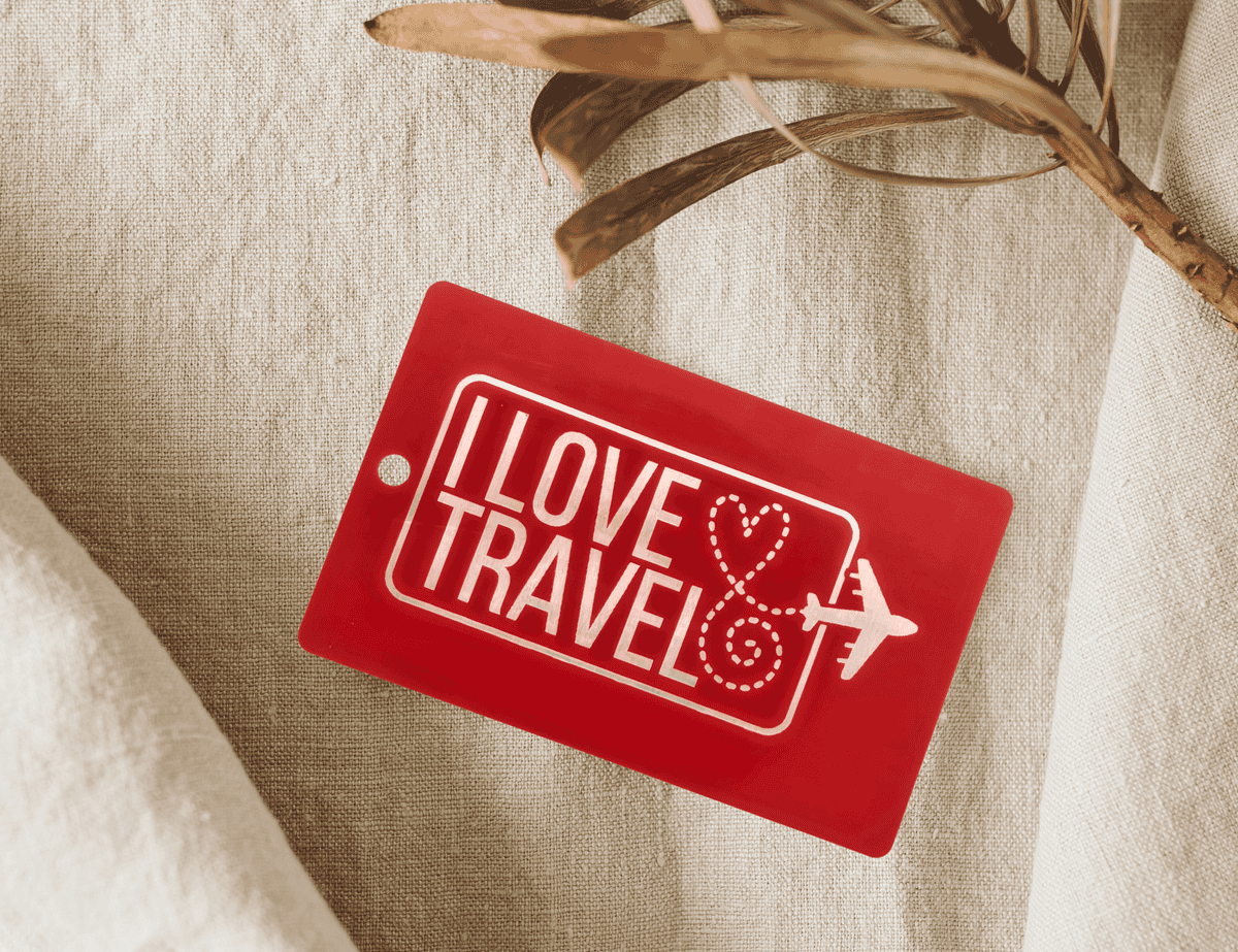 Red engraved luggage tag with “I Love Travel” text and airplane heart design.