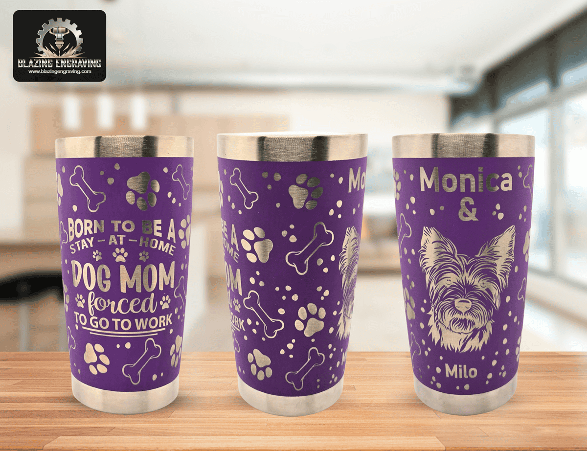 A single purple stainless steel tumbler shown from three different angles to display the full silver laser-engraved design, featuring dog paw prints, bones, the phrase ‘Born to be a stay-at-home dog mom forced to go to work,’ and ‘Monica & Milo’ with a dog illustration. Blazing Engraving logo in the corner.